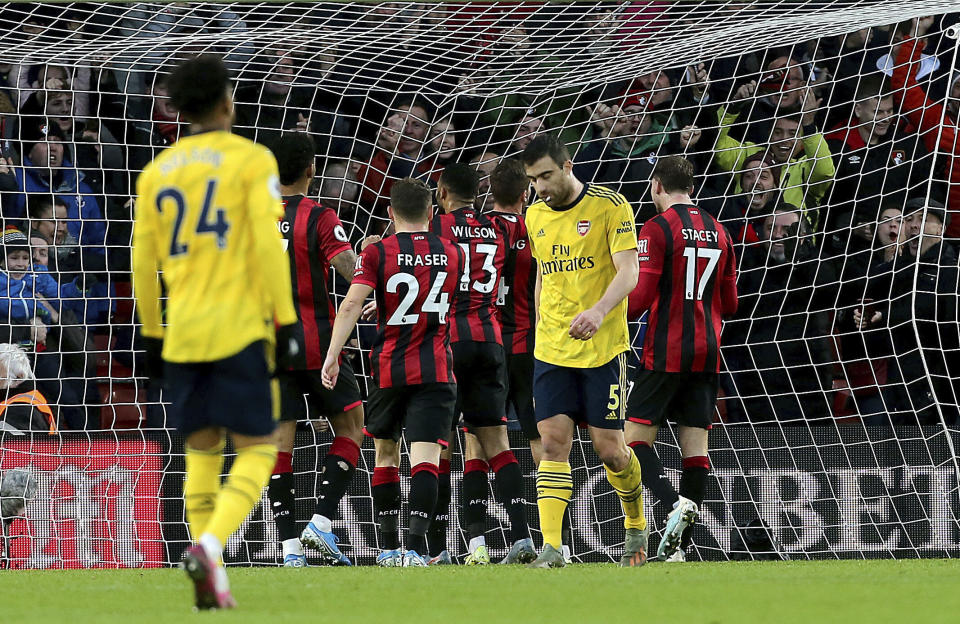 Bournemouth's Dan Gosling, center obscured, celebrates scoring his side's first goal of the game during their English Premier League soccer match against Arsenal at the Vitality Stadium, Bournemouth, England, Thursday, Dec. 26, 2019. (Mark Kerton/PA via AP)