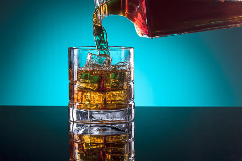 Alcohol being poured into a rocks glass.