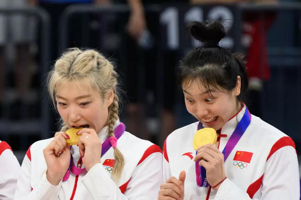 李夢（左）是中國女籃主力，和隊友咬金牌。（法新社）