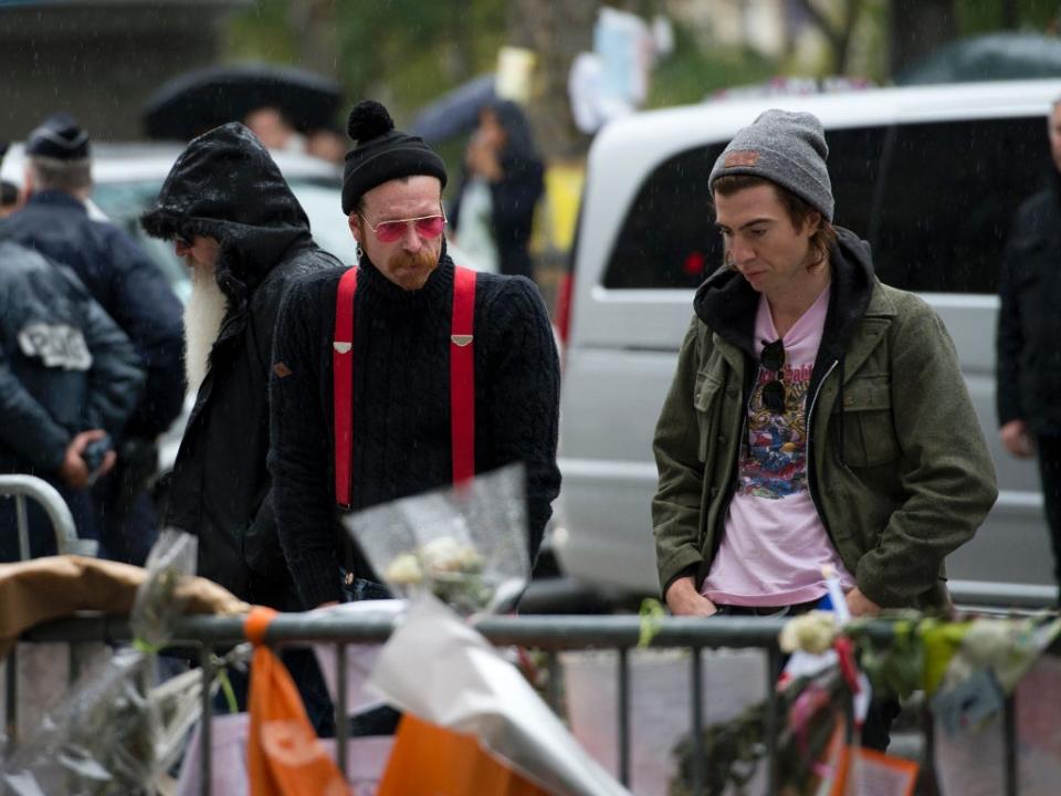 Jesse Hughes and Julian Dorio examine tributes to the victims of the attacks outside the Bataclan in December 2015 (AFP/Getty)