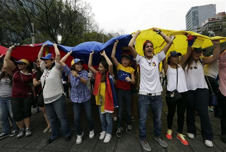 People carry a giant Venezuelan flag during a protest of Venezuelan citizens residing in Mexico, against the government of Venezuela's President Nicolas Maduro and the violence resulting from anti-government protests, in Mexico City February 23, 2014. REUTERS/Henry Romero