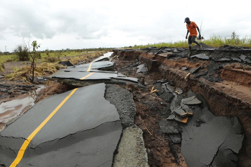 A man passes through a section of the road damaged by Cyclone Idai in Nhamatanda about 50 kilometres from Beira, in Mozambique, Friday March, 22, 2019. As flood waters began to recede in parts of Mozambique on Friday, fears rose that the death toll could soar as bodies are revealed. (AP Photo/Tsvangirayi Mukwazhi)