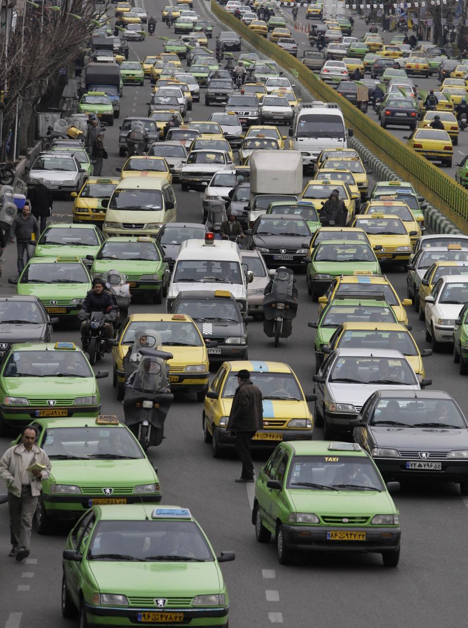 FILE - In this Saturday, Feb. 25, 2012, file photo, cars drive in a congested traffic in a central square of Tehran. For many business leaders, Iran is a mouthwatering emerging market, and they could soon find themselves heading to Iran to secure new deals following the suspension of the first international sanctions. (AP Photo/Vahid Salemi, File)