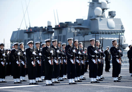 Members of the Japan Maritime Self-Defense Force (JMSDF) attend a handover ceremony for the JMSDF latest Izumo-class helicopter carrier DDH-184 Kaga by Japan Marine United Corporation in Yokohama, Japan, March 22, 2017. REUTERS/Toru Hanai