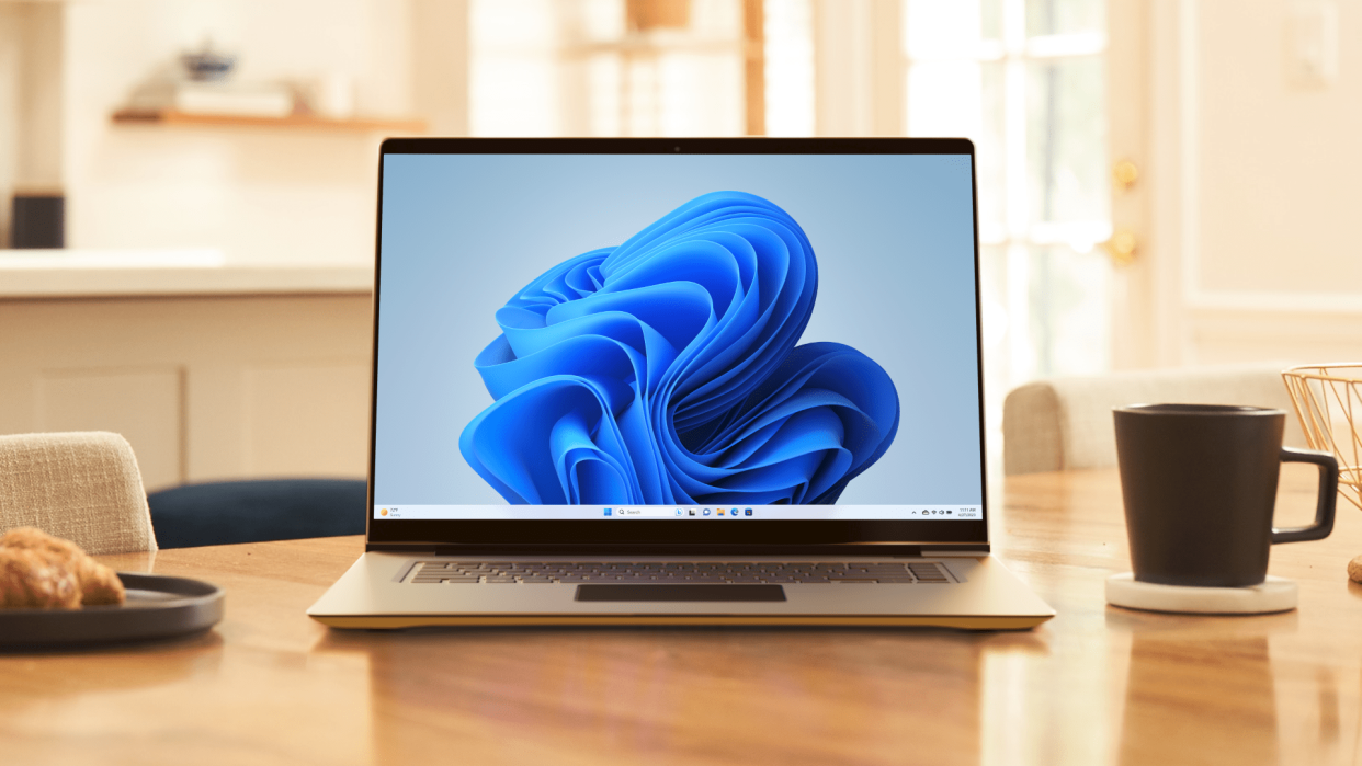  A laptop on a desk with the Windows 11 background on its screen. 