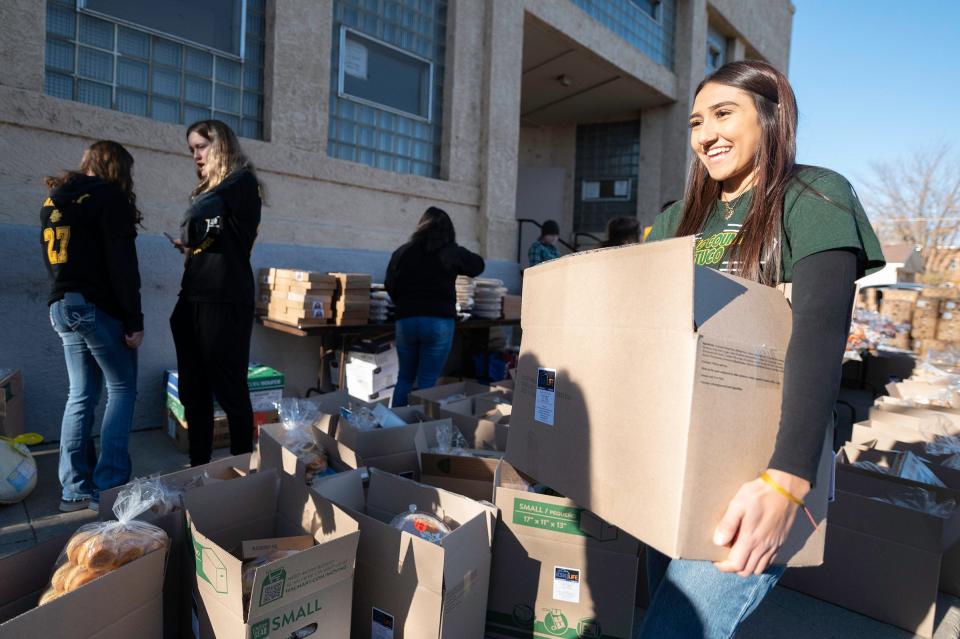 Pueblo County's Mia Gallegos-Herrera carries a box of food to be delivered during the Tom and Louie's Cupboard food drive at St. Joseph's Hall on Saturday, November 18, 2023.