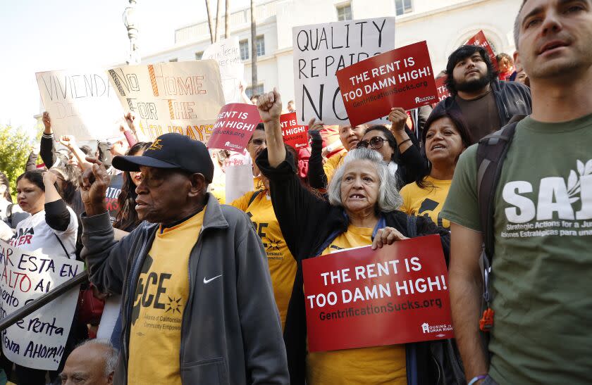 LOS ANGELES, CA - OCTOBER 15, 2019 82-year-old Joe Stringer, left, and Maria Gomez,64, right, join advocates and tenants during a press conference on Los Angeles City Hall steps before the L.A. City Council is expected to vote Tuesday on an eviction moratorium to prevent landlords from removing tenants prior to new statewide rental rules that take effect in January. (Al Seib / Los Angeles Times)