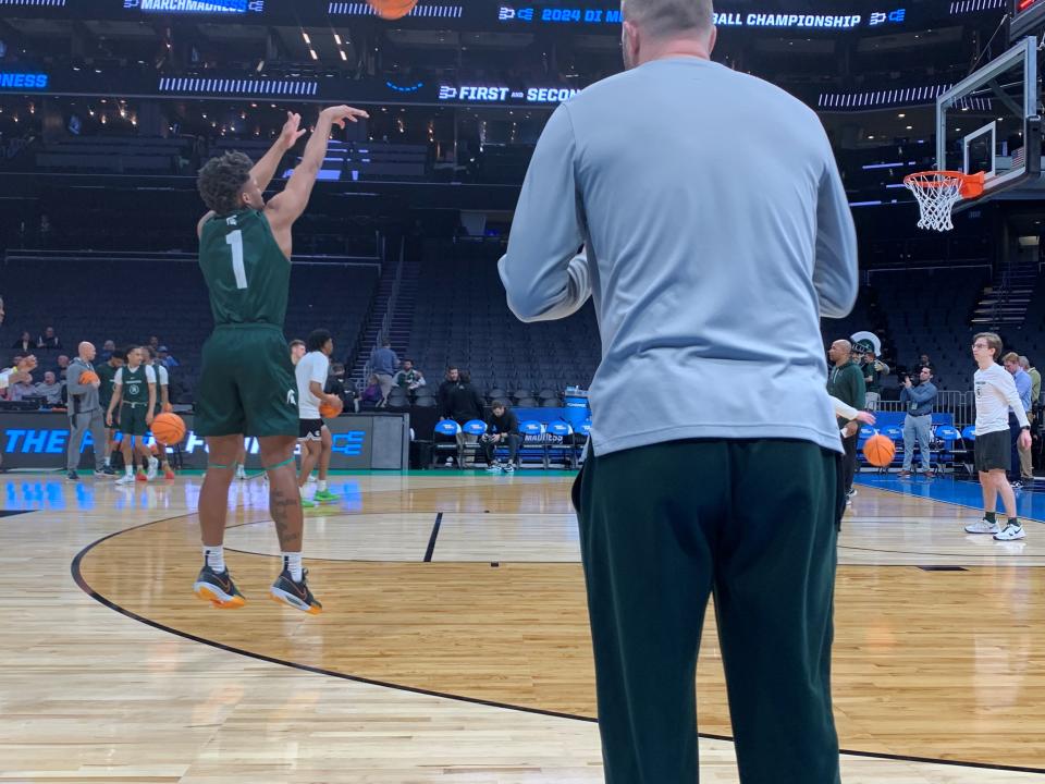 Jeremy Fears takes a jump shot as team video coordinator and former player Austin Thornton watches during Michigan State basketball's open practice Wednesday, March 20, 2024, at Spectrum Center in Charlotte, N.C. The Spartans face Mississippi State in the NCAA tournament, but Fears remains out after being shot in December 2023.