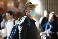 A man wearing a protective mask waits at the arrival hall in Ben Gurion Airport near Tel Aviv, Israel, Thursday, Feb. 27, 2020. Israel on Wednesday advised its citizens to reconsider all foreign travel amid the global spread of the new coronavirus that was first reported in China. (AP Photo/Ariel Schalit)