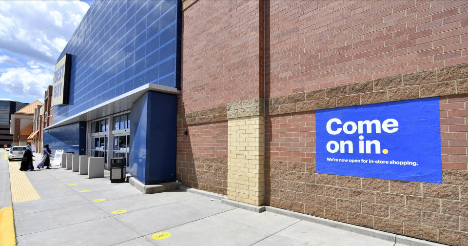 Shoppers, left, head to the entrance as a sign on the outside wall invites customers to shop inside a Best Buy store Wednesday, June 24, 2020 in Richfield, Minn. as restrictions due to the coronavirus have eased in Minnesota. (AP Photo/Jim Mone)