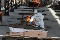 A man performs the final rites of a relative who died of COVID-19, at a crematorium in Jammu, India, Friday, April 23, 2021. India’s underfunded health system is tattering as the world’s worst coronavirus surge wears out the nation, which set another global record in daily infections for a second straight day with 332,730. India has confirmed 16 million cases so far, second only to the United States in a country of nearly 1.4 billion people. (AP Photo/Channi Anand)