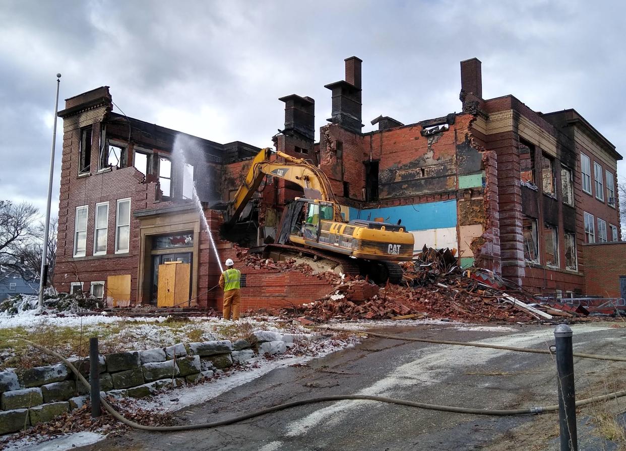 A wrecking crew tears down the former Lawndale Elementary School on Friday after a fire destroyed the Akron building at 2330 25th St. SW in Kenmore.