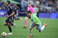 Seattle Sounders forward Raúl Ruidíaz loses his footing as he runs for the ball against Vancouver Whitecaps defender Bjorn Inge Utvik, left, during the first half of an MLS soccer match Saturday, April 20, 2024, in Seattle. (AP Photo/Lindsey Wasson)