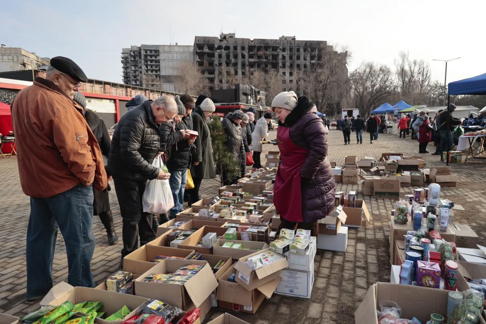 Local people buy and sell food ahead of Christmas and the New Year festivities in Mariupol, in Russian-controlled Donetsk region, eastern Ukraine, Saturday, Dec. 24, 2022. (AP Photo/Alexei Alexandrov)