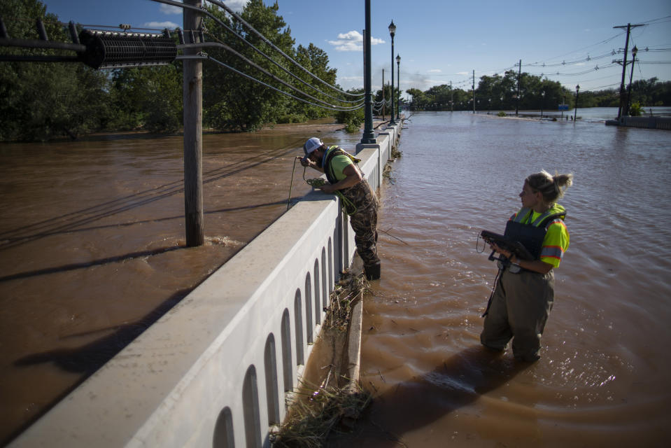 United States Geological Survey workers measure the floodwaters along the Raritan River in Somerville, N.J. Thursday, Sept. 2, 2021. A stunned U.S. East Coast faced a rising death toll, surging rivers, tornado damage and continuing calls for rescue Thursday after the remnants of Hurricane Ida walloped the region with record-breaking rain. (AP Photo/Eduardo Munoz Alvarez)