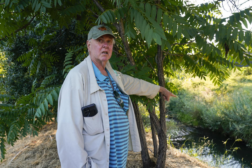Rusty Cohn points to Napa Creek where he says he frequently sees beavers, Wednesday, July 19, 2023, in Napa, Calif. (AP Photo/Godofredo A. Vásquez)