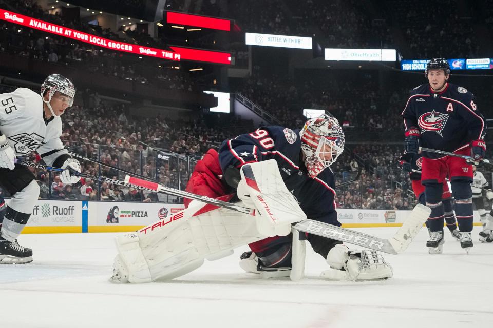 Dec 5, 2023; Columbus, Ohio, USA; Columbus Blue Jackets goaltender Elvis Merzlikins (90) covers a puck in front of Los Angeles Kings center Quinton Byfield (55) during the second period of the NHL game at Nationwide Arena.