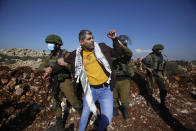 Israeli soldiers arrest a Palestinian during a protest against the expansion of Jewish settlements near the West Bank town of Salfit, Monday, Nov. 30, 2020. In years to come, Israelis will be able to commute into Jerusalem and Tel Aviv from settlements deep inside the West Bank via highways, tunnels and overpasses that cut a wide berth around Palestinian towns. Rights groups say the new roads that are being built will set the stage for explosive settlement growth, even if President-elect Joe Biden's administration somehow convinces Israel to curb its housing construction. (AP Photo/Majdi Mohammed)