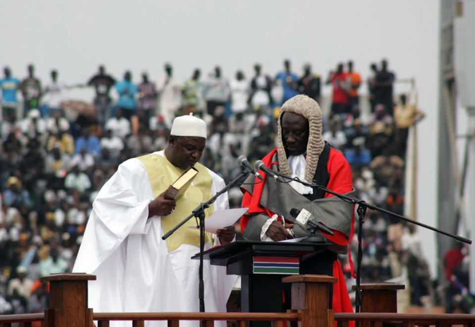 Gambia President Adama Barrow, left, reads, during his inauguration ceremony in Banjul , Gambia, Saturday, Feb. 18, 2017. Gambia's new president thanked his nation and promised greater freedom, an improved economy and better education as thousands attended a ceremony Saturday marking his inauguration after a tense political standoff with the country's former longtime leader. (AP Photo/ Kuku Marong)