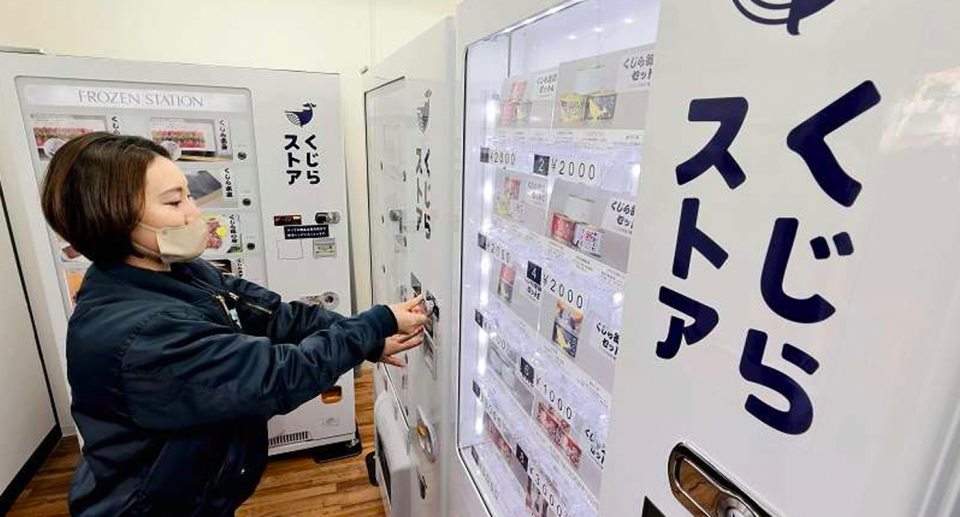 A woman makes a purchase from a Japanese vending machine that reads Kujira Store in Japanese (Whale store).