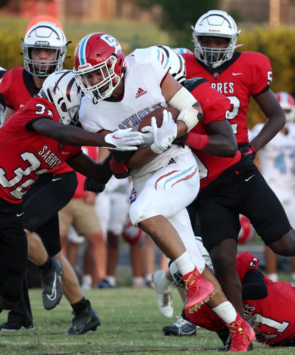 Charlotte Catholic running back Jake Anderson fights his way up the middle of the field for yardage as the South Meck defense attempts to make the tackle during first half action on Friday, August 18, 2023 at South Meck High School. 