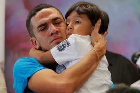 Javier, a 30-year-old from Honduras, holds his 4-year-old son William during a media availability in New York after they were reunited after being separated for 55 days following their detention at the Texas border, July 11, 2018. REUTERS/Lucas Jackson