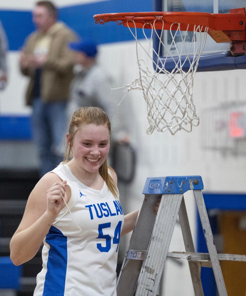 Tuslaw's Breanna McCabe poses for a photo after cutting the net following a win over CVCA to give the Mustangs a share of the PAC 7 girls basketball championship, Wednesday, Feb. 7, 2024.