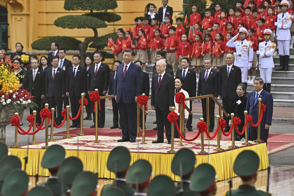 China's President Xi Jinping, center left, and Vietnam's Communist Party General Secretary Nguyen Phu Trong, center right, attend a welcome ceremony at the Presidential Palace in Hanoi, Vietnam, Tuesday Dec. 12, 2023. (Nhac Nguyen/Pool via AP)