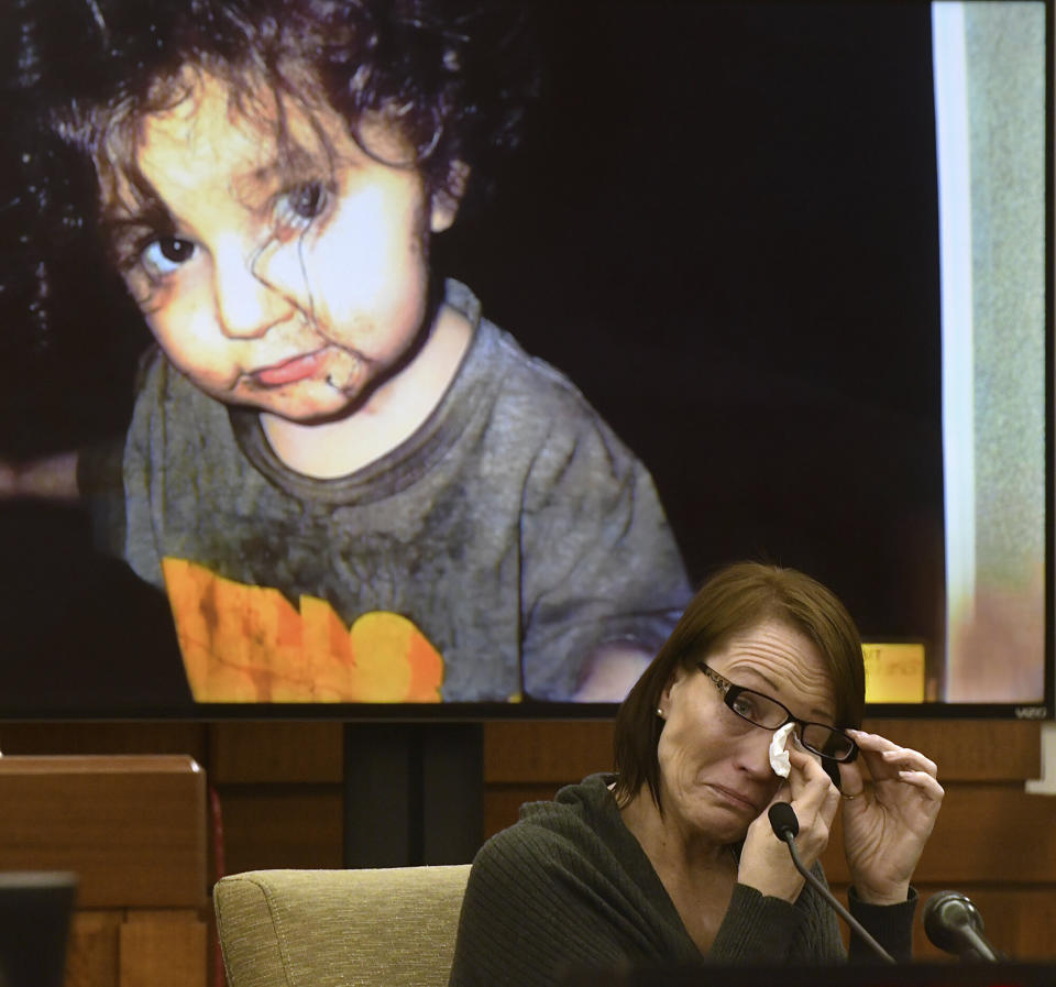 A photograph of one of the children is displayed in court as neighbour Betsy Broown weeps in the witness stand. 