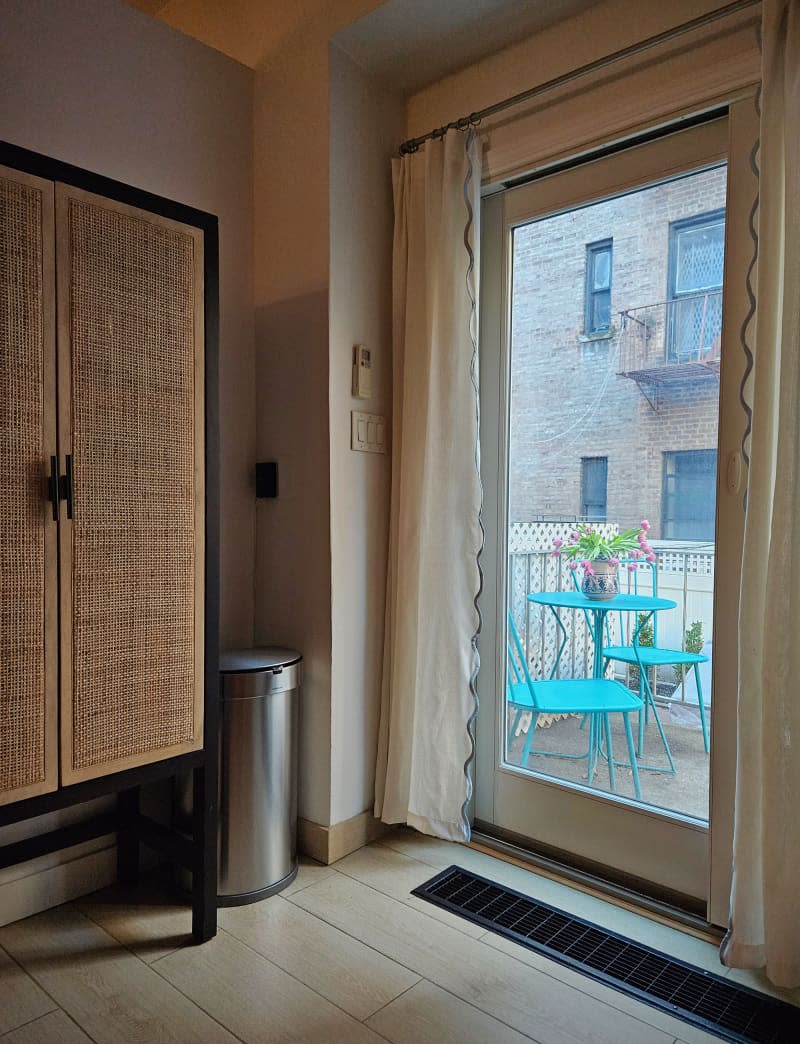 corner of kitchen with rattan cabinet and door to outdoor patio