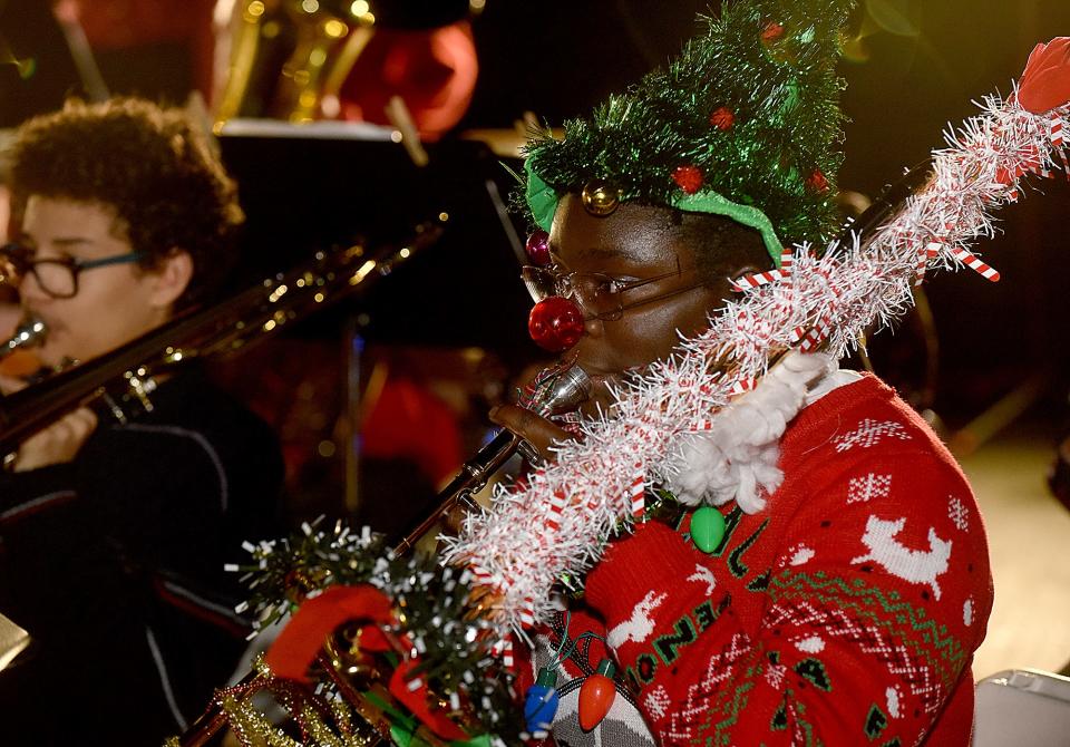 Osima Adejo, 14, a student at West Middle School, plays the trombone Thursday as band members perform Christmas music at Shelter Insurance’s 56th annual Christmas tree-lighting ceremony at 1817 W. Broadway.