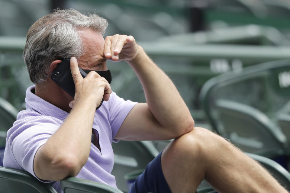 FILE - Chicago Cubs general manager Jed Hoyer talks on the phone as he watches players during the baseball team's practice at Wrigley Field in Chicago, in this Wednesday, July 8, 2020, file photo. Hoyer insisted the Chicago Cubs are taking a different approach this time. They plan to remain competitive while they retool rather than bring out the wrecking ball the way they did nine years ago. (AP Photo/Nam Y. Huh, File)