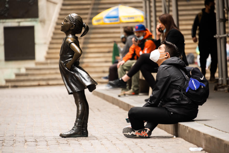 NEW YORK, NEW YORK - MAY 11: A person sits by the Fearless Girl Statue in front of the New York Stock Exchange in Wall Street on May 11, 2021 in New York City. New York Governor Andrew Cuomo announced pandemic restrictions to be lifted on May 19.  (Photo by Noam Galai/Getty Images)