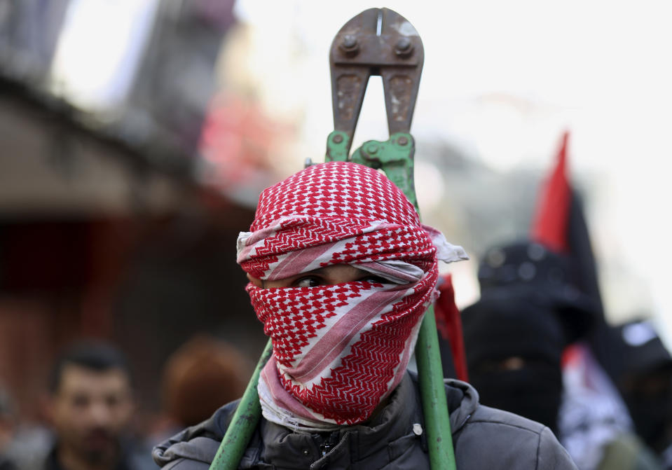 Masked member of Hamas holds an iron scissors during a protest against the Mideast plan announced by U.S. President Donald Trump, after the Friday prayer at the main road in Gaza City, Friday, Jan. 31, 2020. (AP Photo/Adel Hana)