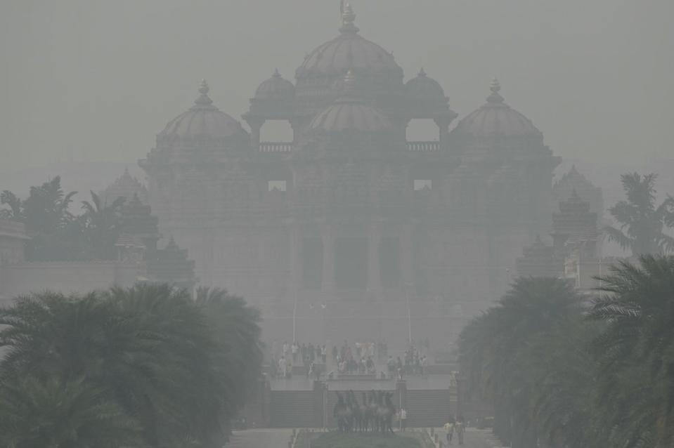 The Akshardham temple is seen amid heavy smog conditions in New Delhi on 9 November (AFP via Getty Images)