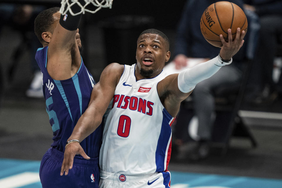 Detroit Pistons guard Dennis Smith Jr. (0) drives to the basket past Charlotte Hornets forward P.J. Washington, left, during the first half of an NBA basketball game in Charlotte, N.C., Thursday, March 11, 2021. (AP Photo/Jacob Kupferman)