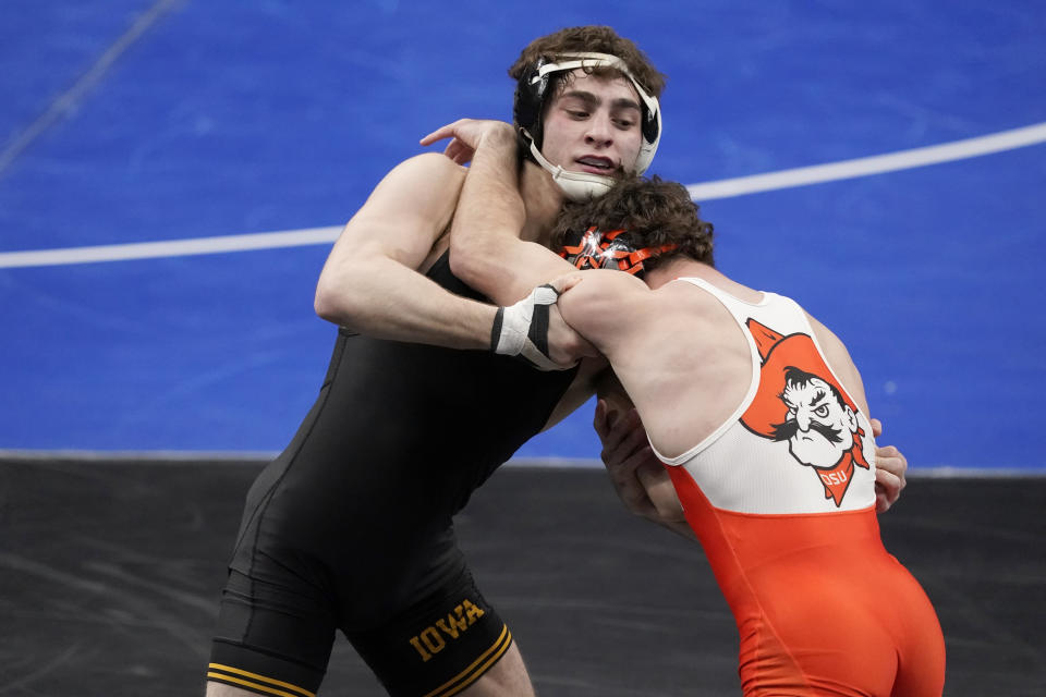 Oklahoma State's Daton Fix, right, takes on Iowa's Austin DeSanto during their 133-pound match in the semifinal round of the NCAA wrestling championships Friday, March 19, 2021, in St. Louis. (AP Photo/Jeff Roberson)