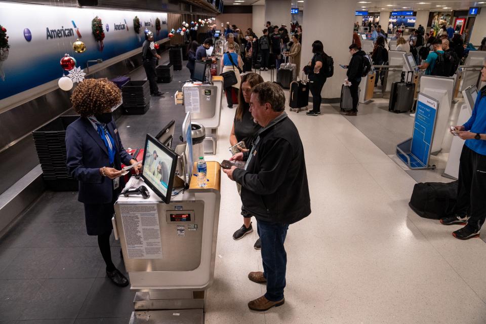 People check in for their flights at Terminal 4 at Phoenix Sky Harbor International Airport in Phoenix on Dec. 21, 2023.