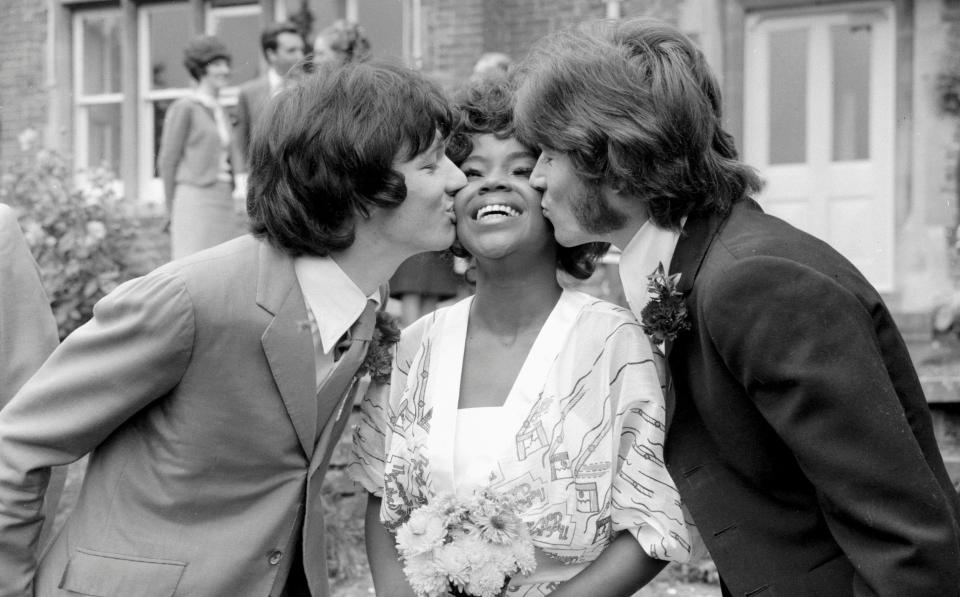 Arnold receiving a kiss from her husband Jim Morris (left) and Barry Gibb of the Bee Gees on her wedding day October 1968 - Mirrorpix