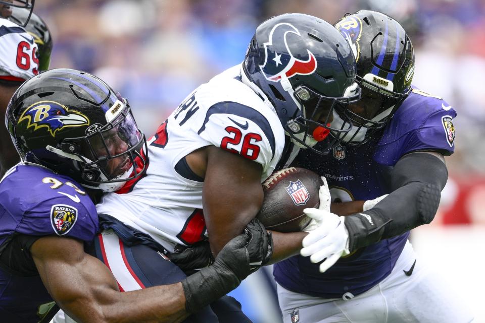 Houston Texans' Devin Singletary is stopped by Baltimore Ravens' Odafe Oweh and Roquan Smith during the first half of an NFL football game Sunday, Sept. 10, 2023, in Baltimore. (AP Photo/Nick Wass)