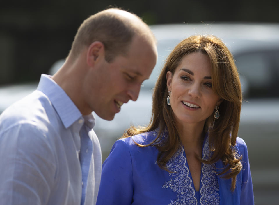 Wearing a traditional Pakistani dress called a Kurta, Britain's Princess Kate speaks to Prince William during her visit with teachers in a suburb of Islamabad, Pakistan, Tuesday, Oct. 15, 2019. The Duke and Duchess of Cambridge, who are strong advocates of girls' education were greeted by teachers and children. (AP Photo/B.K. Bangash)