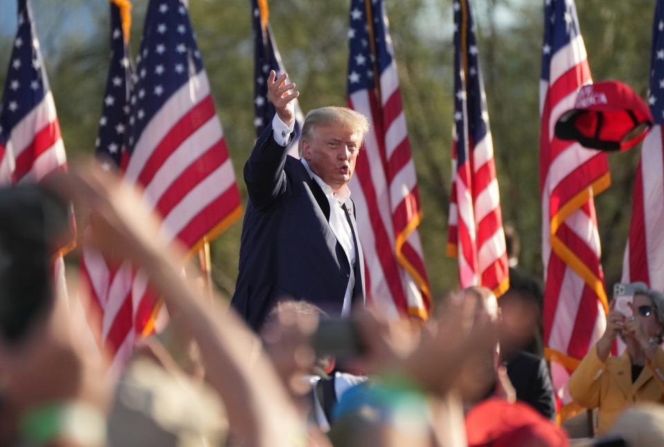 Former President Donald Trump throws hats to people gathered at Legacy Sports Park in Mesa on Sunday, Oct. 9, 2022. Trump is in town to rally for Kari Lake, Blake Masters and other local Republican ticket candidates.