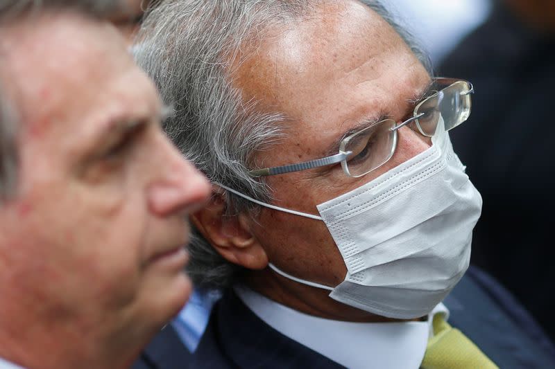 Brazil's Economy Minister Paulo Guedes looks on next to Brazil's President Jair Bolsonaro during a news conference, after a meeting with President of Brazil's Supreme Federal Court Dias Toffoli, amid the coronavirus disease (COVID-19) outbreak in Brasilia