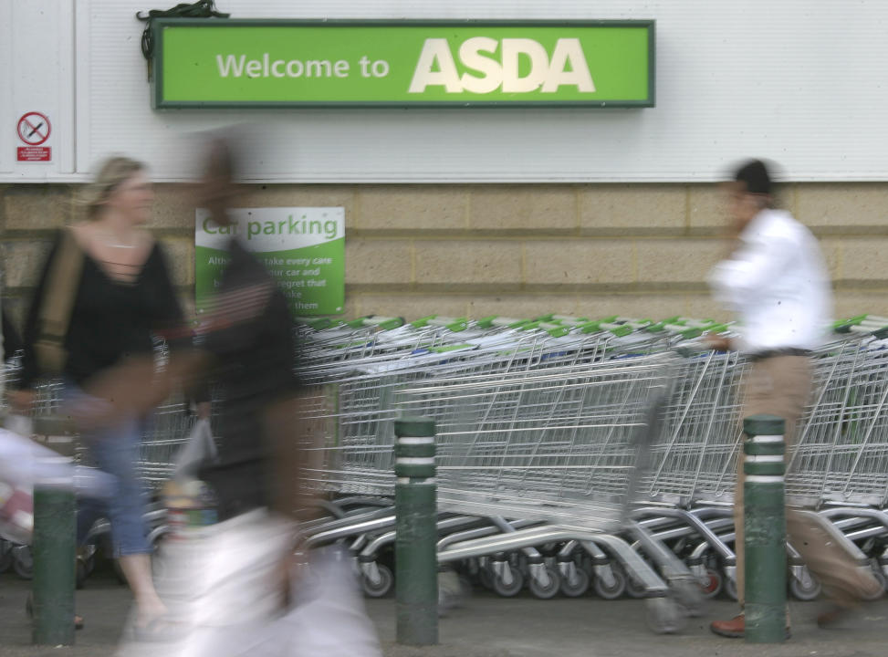 FILE - In this Tuesday July 17, 2007 filer, shoppers enter the Asda supermarket in Wallington, England. Retail giant Walmart has agreed to sell its British chain of supermarkets, Asda, to the investors behind an international group of gas stations and food shops in a deal that values the company at 6.8 billion pounds ($8.8 billion). Brothers Mohsin and Zuber Issa, along with investors TDR Capital will acquire a majority of Asda, while Walmart will retain a minority stake and a seat of the board, the parties said in a joint statement issued Friday. Details of the deal weren’t released. (AP Photo/Tom Hevezi, File)