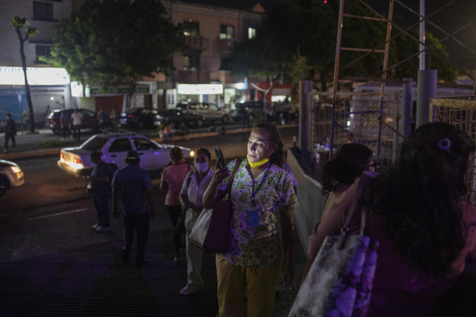 Health workers check their mobile phones as they stand outside Veracruz General Hospital after a strong earthquake, in Veracruz, Mexico, Tuesday, Sept. 7, 2021. The quake struck southern Mexico near the resort of Acapulco, causing buildings to rock and sway in Mexico City nearly 200 miles away. (AP Photo/Felix Marquez)