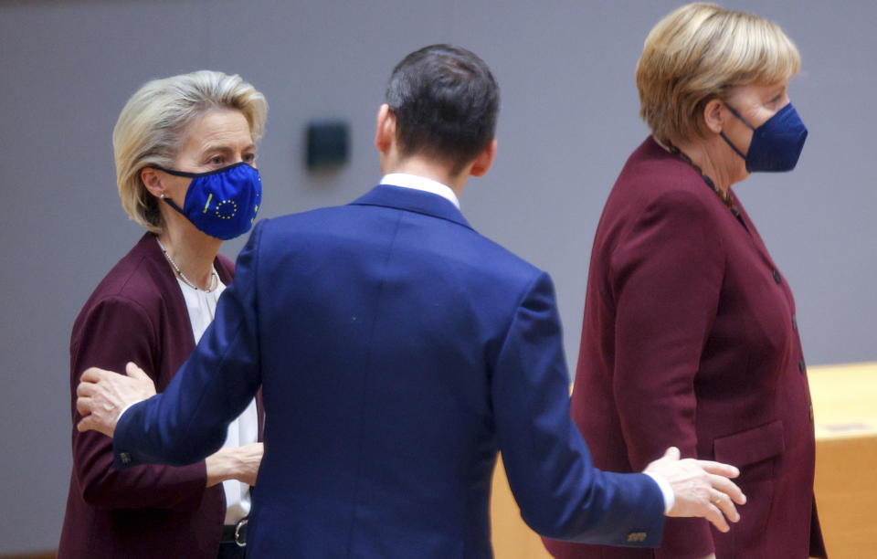 Poland's Prime Minister Mateusz Morawiecki, center, speaks with European Commission President Ursula von der Leyen, left, and German Chancellor Angela Merkel during a round table meeting at an EU summit in Brussels, Friday, Oct. 22, 2021. European Union leaders conclude a two-day summit on Friday in which they discussed issues such as climate change, the energy crisis, COVID-19 developments and migration.(AP Photo/Olivier Matthys, Pool)