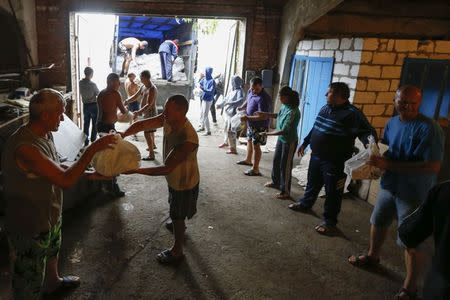 Ukrainian volunteers unload bags of food for refugees in the southern coastal town of Mariupol September 10, 2014. REUTERS/Vasily Fedosenko