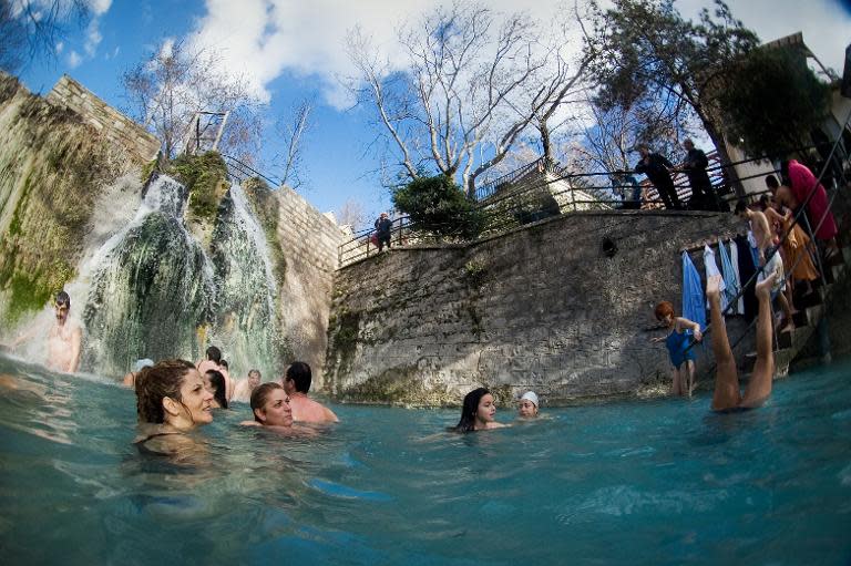 People bathe in a hot spring at Loutraki near the village of Aridea in northern Greece