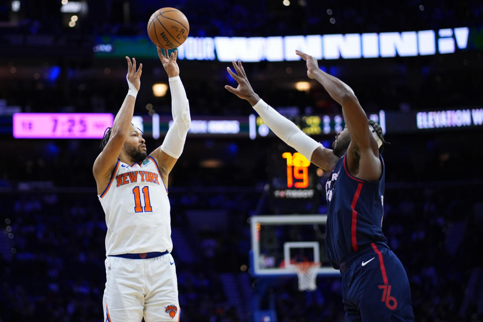 New York Knicks' Jalen Brunson, left, goes up for a shot against Philadelphia 76ers' Buddy Hield during the first half of an NBA basketball game, Thursday, Feb. 22, 2024, in Philadelphia. (AP Photo/Matt Slocum)