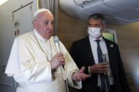 Pope Francis speaks to journalists, Monday, March 8, 2021, while flying back to The Vatican at the end of his four-day trip to Iraq where he met with different Christian communities and Shiite revered cleric Grand Ayatollah Ali al-Sistani. At right pope's spokesperson Matteo Bruni. (AP Photo/Yara Nardi, pool)